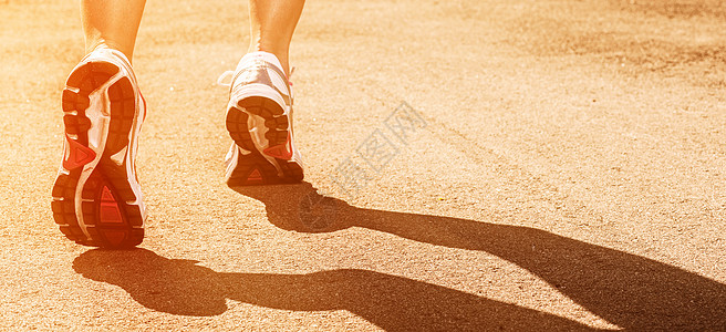 在沥青上穿运动鞋的妇女腿街道成人运动员火车女孩鞋类肌肉城市跑步赛跑者图片