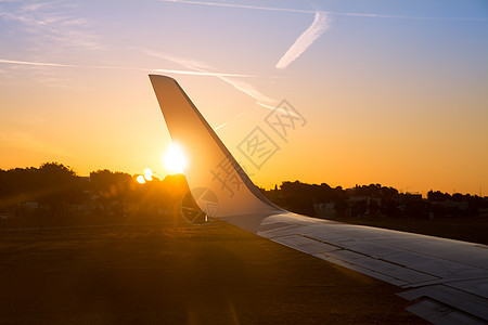 日落时空飞机喷气机翼 有金色阳光水分运输发束旅行晴天气候天空假期涡轮青色图片