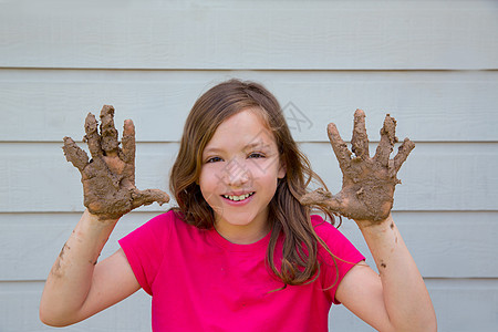 带着脏手笑着玩泥巴的快乐女孩女性闲暇黑发地面黏土童年衬衫孩子享受头发图片