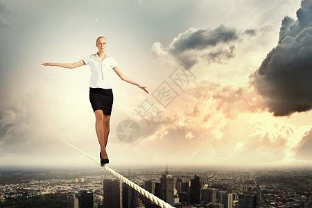 商业妇女靠绳索平衡天空风暴冠军人士勇气行动商务成功杂技风险图片