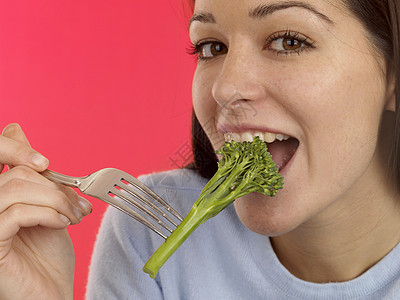 女孩吃花椰菜Broccoli零食叉子女士食物幸福蔬菜投标女性饮食小吃图片