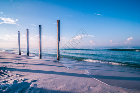 古旧码头堆积物支持沿沙滩站立的柱子图片