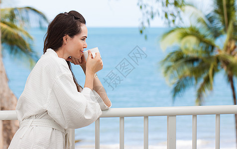妇女早上喝咖啡阳台杯子黑发早餐咖啡假期女孩饮料奢华海洋图片