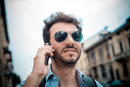 男人在街上打电话手机电话胡子呼唤微笑城市生活沟通街道太阳镜城市背景图片