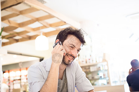 在酒吧的男人在电话胡子城市生活手机日常生活咖啡沟通呼唤微笑早餐图片