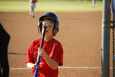 棒球男孩盯着球棒看图片