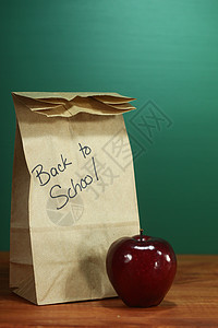 学校午餐沙包坐在教师桌旁学期解雇大学家庭作业时间桌子课堂老师新学期黑板图片
