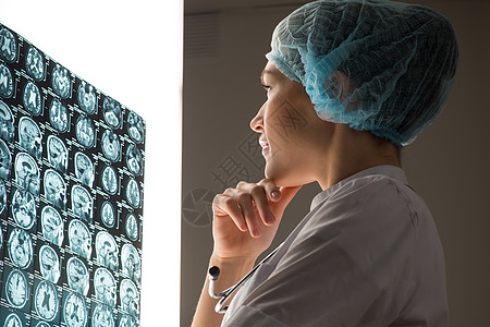 脑CT片医生看X光片女性外套职业成人x光护士诊断实验蓝色检查背景