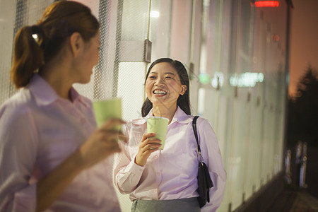 青年女商务人士在户外微笑和喝咖啡图片