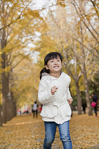 在公园玩耍的年轻女孩低角度童年毛衣休闲亲热团结微笑树区俏皮衣物图片