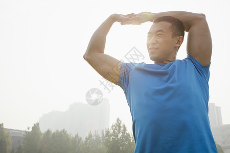 北京铜锅年轻的肌肉人伸展力量生活方式风光耀斑竞技锻炼年轻人蓝色收腰公园背景