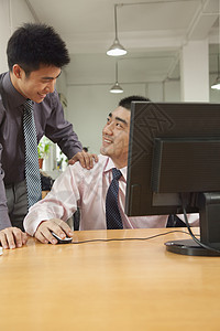 在计算机屏幕上讨论该项目的共同工作人 员业务电脑黑发团队写作收腰技术两个人白领衬衫图片