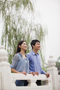 在桥上的年轻夫妇年轻人文化收腰亲热休闲团结微笑建筑学蓝色沉思图片