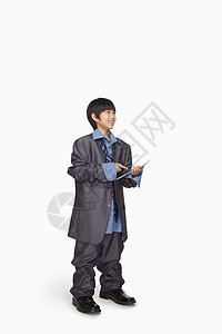 男孩装扮成商务人士使用平板电脑图片