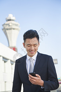 旅行者在机场查看手机信息 (单位 美元)图片