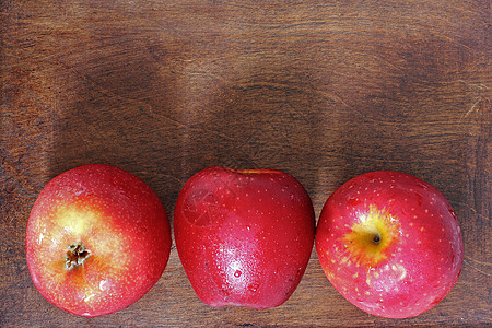 木头上三个苹果营养饮食花园桌子叶子季节食物团体甜点水果图片