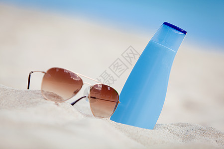 太阳墨镜和奶油的暑假产品防晒霜晒黑闲暇洗剂太阳镜日光浴蓝色旅行海洋图片