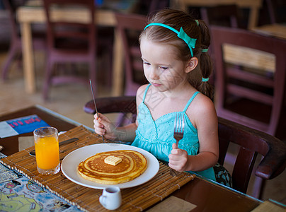 可爱的小女孩在度假餐厅吃早饭 很可爱食物面包生活酒店果汁小吃桌子橙子快乐羊角图片