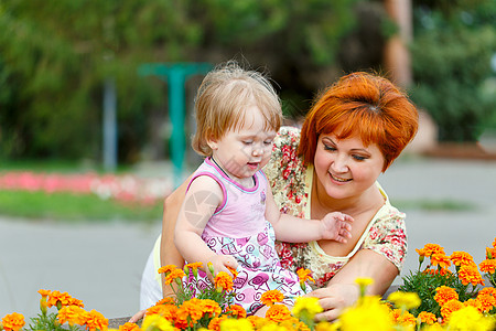 家庭 母亲和女儿女儿身公园妈妈婴儿花期光束花朵微笑童年幸福图片
