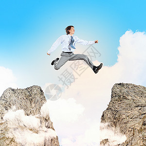 商务人士跨越了差距跳跃喜悦岩石经理成就悬崖自由管理人员顶峰公司图片