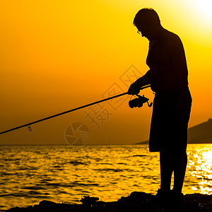 富彩的日落时 渔夫在海滩上的轮廓支撑天空钓鱼海岸晴天橙子食物爱好海鲜钓竿图片