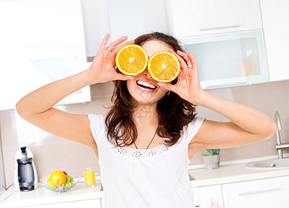 年轻健康有趣的女人 的肖像 眼上涂着橙子厨房眼睛橘子女士食物妻子女性茶点水果幸福图片