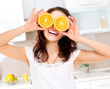 年轻健康有趣的女人 的肖像 眼上涂着橙子茶点食物妻子黑发厨房眼睛幸福身体水果女性图片