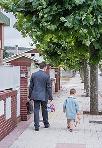 父亲和小儿子在街上走到学校里图片