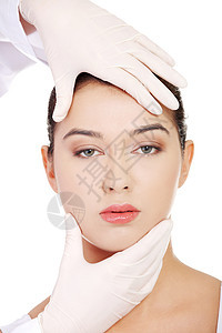 医生用手套触摸美丽的女人的面孔治疗外科手术药品身体女士塑料化妆品工作室矫正图片