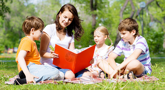 教师读书给夏季公园的孩子看书童年女孩幸福微笑快乐婴儿后院学习朋友们乐趣图片