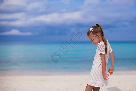 在热带沙滩度假中行走的可爱小女孩图片