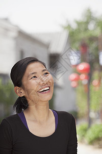 年轻女子笑着看远去省会服装乐趣黑发城市幸福摄影休闲享受长发图片