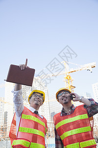 两名建筑师对着建筑工地看望和指向建筑工地图片