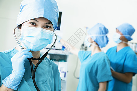 手术室外科医生小组 女性外科医生手持听诊器和照相机团结防护团队权威三个人职业收腰医护人员保健专业图片