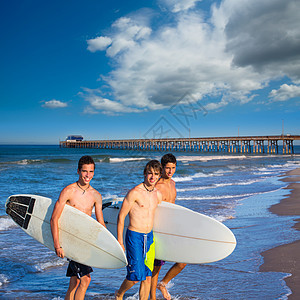 男孩冲浪者小组 从海滩出来波浪太阳冲浪板团队码头微笑自由青年享受假期图片