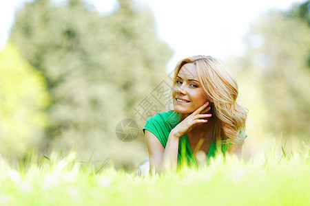 女人躺在草地上晴天绿色公园女孩快乐成人微笑闲暇幸福说谎图片