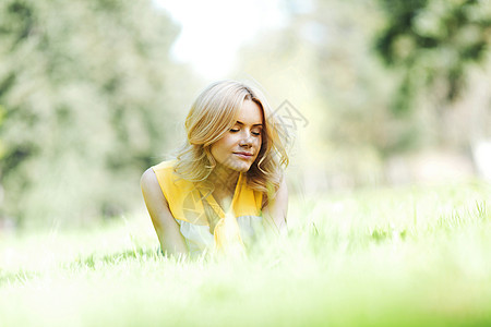 女人躺在草地上自由幸福闲暇绿色快乐黄色女孩金发女性说谎图片