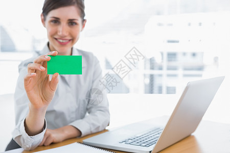 展示绿色商业名卡的青年女商务人士图片