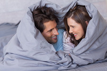 快乐的一对情侣 在他们的睡衣包着欢乐图片