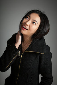 有吸引力的亚洲女孩 20岁在演播室拍摄黑发女性成功成人快乐拉链冒充冬衣灰色外套图片