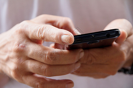 男人检查他的手机短信消息男性触摸屏商业自然光互联网网络电话媒体图片