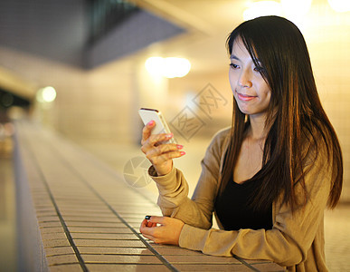 晚上使用智能手机的亚洲妇女图片