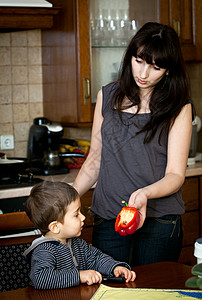 妈妈儿子母亲向孩子提供红色保加利亚胡椒背景