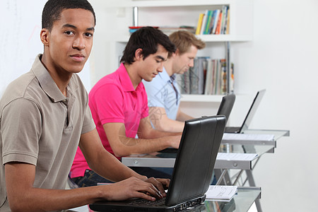 青年男子在计算机实验室工作 从事他们的任务压力办公桌图书考试男人学校黑色混血电脑大学图片