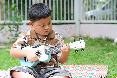 男孩玩的尤里乐乐趣童年男性男生细绳吉他木头音乐家微笑孩子教育图片