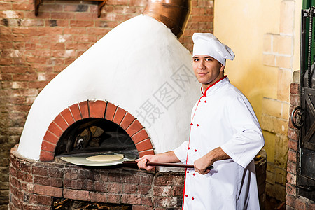 厨师在烤箱里放钱做披萨员工面团火焰木板壁炉柜台餐厅食堂成人美食图片