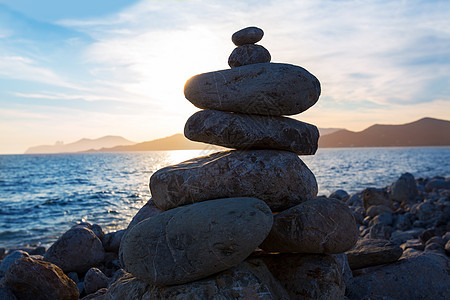 海滩日落 有欲望的石头滚动反射晴天地平线阳光海景猎鹰海岸太阳天空图片