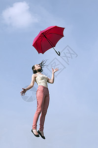 妇女用伞跳跃自由女孩天空遮阳棚蓝色微笑女子飞行风暴喜悦图片