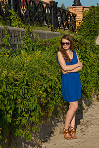 穿着蓝裙子的女孩 在公园里青少年自由草地女性衣服棕褐色太阳微笑花园幸福图片
