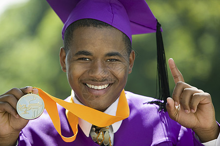 一位男性毕业生的近视肖像 一枚勋章举着一只手指图片